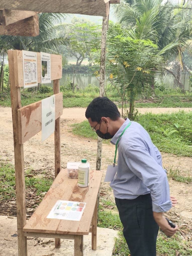 ASEAN delegate examining a biological control agent display outdoors